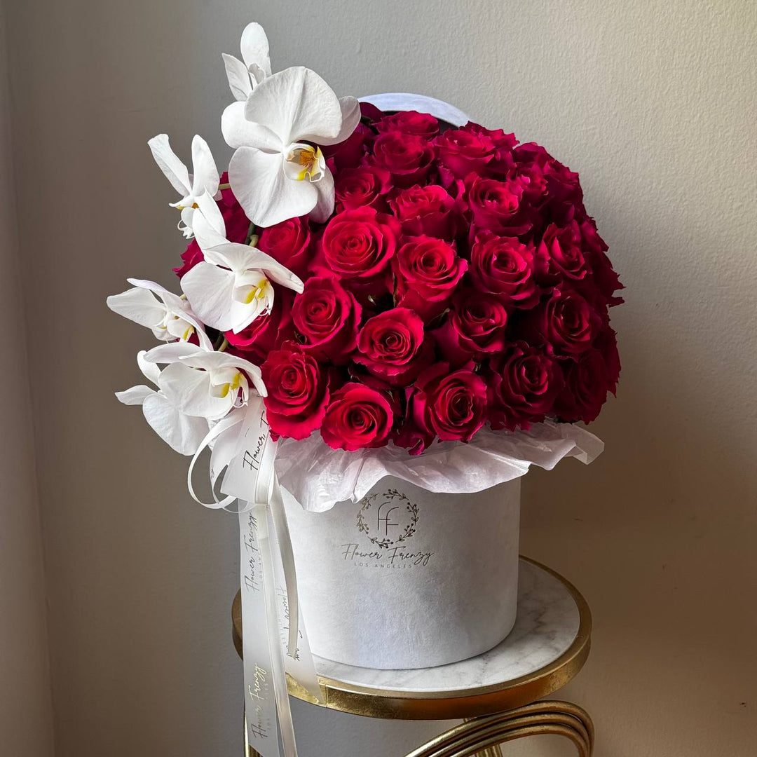 435. Pink roses and orchids in a white box.