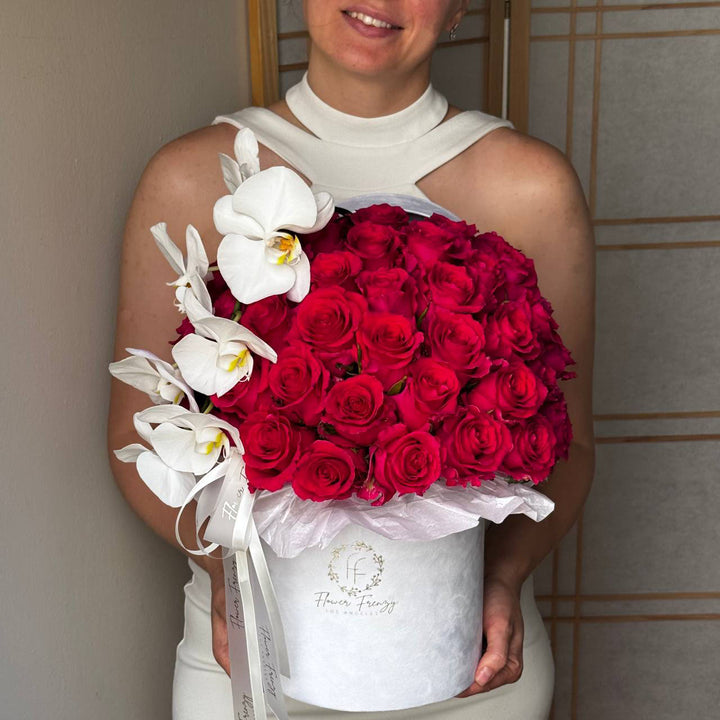 435. Pink roses and orchids in a white box.