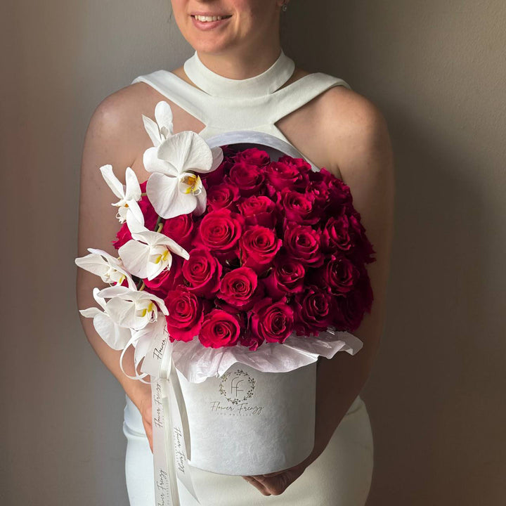 435. Pink roses and orchids in a white box.